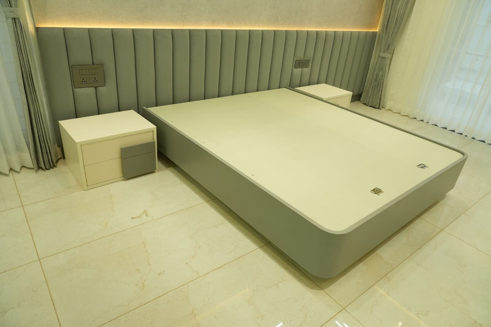 Modern bedroom with platform bed and elegant headboard lighting - Sri Sai Interiors