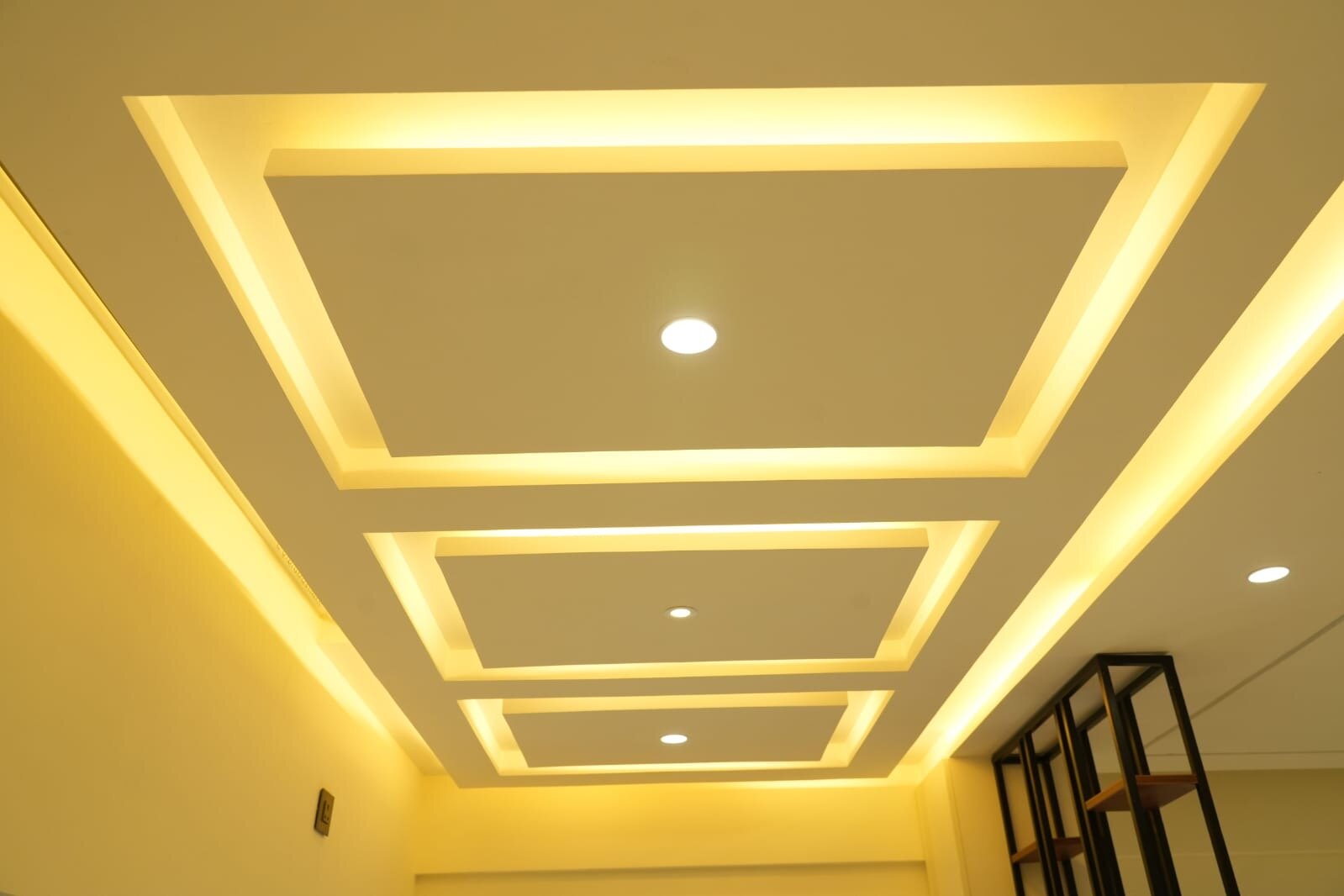 Modern ceiling design with recessed panels and golden LED lighting